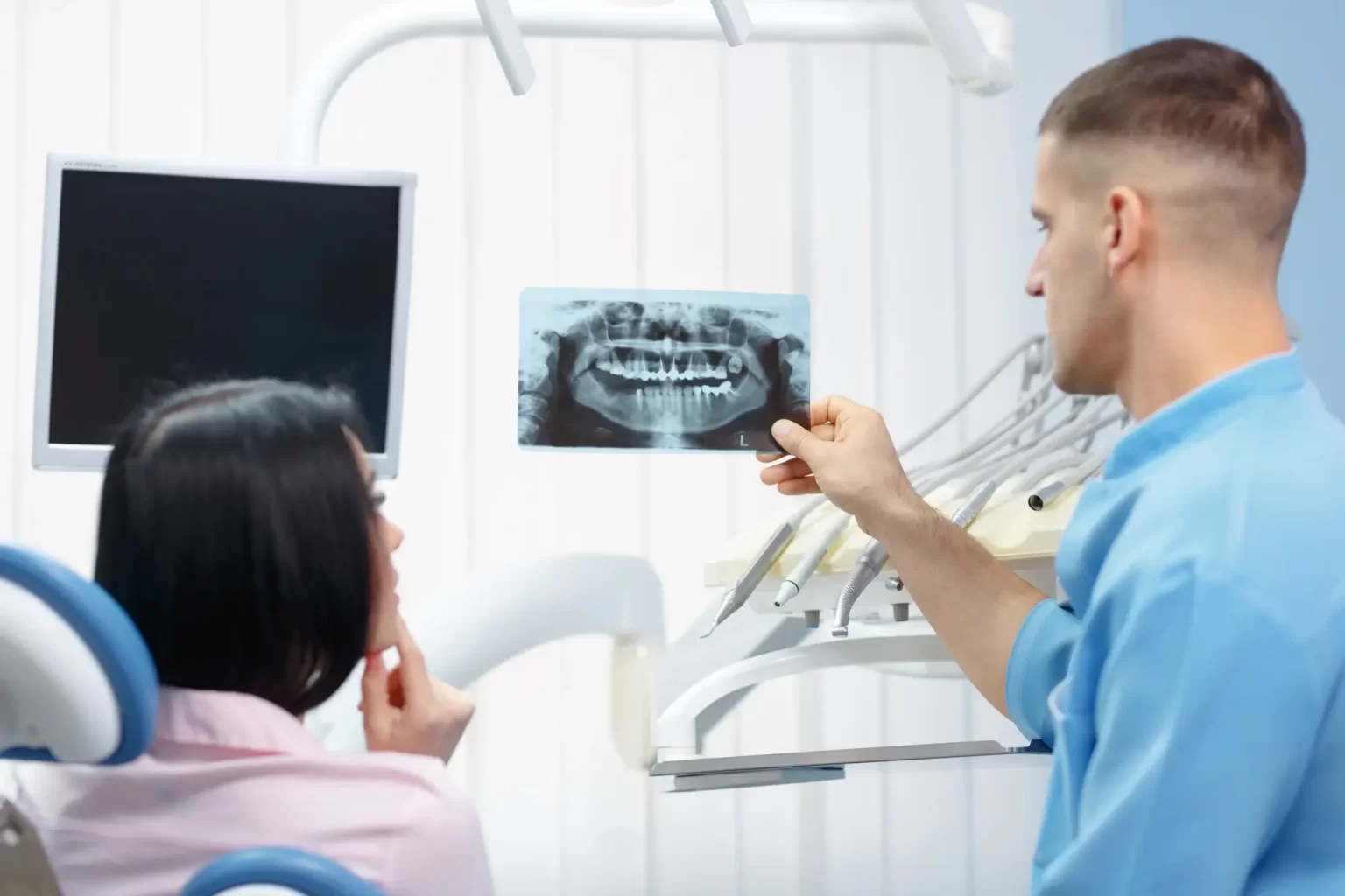 Ein Zahnarzt zeigt einer Patientin einen Scan ihrer Zähne.